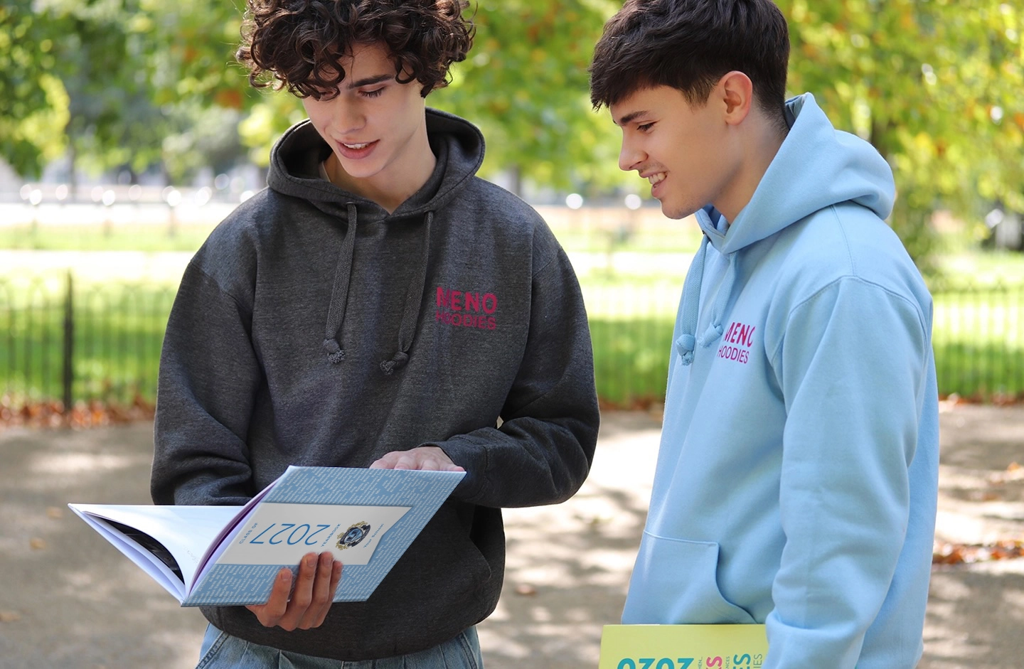 Students holding yearbooks and hoodies